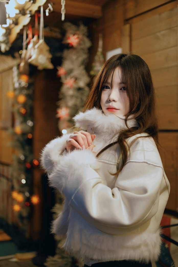 Woman in white fur jacket with festive lights