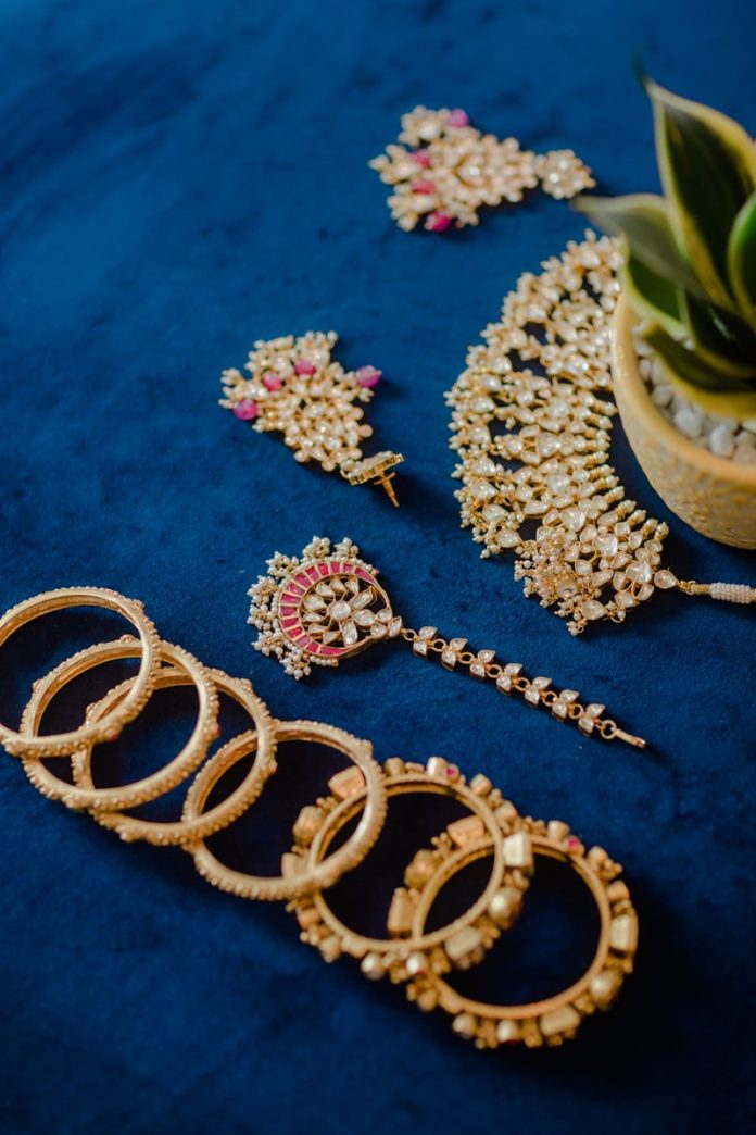 A bunch of jewelry laying on a blue surface