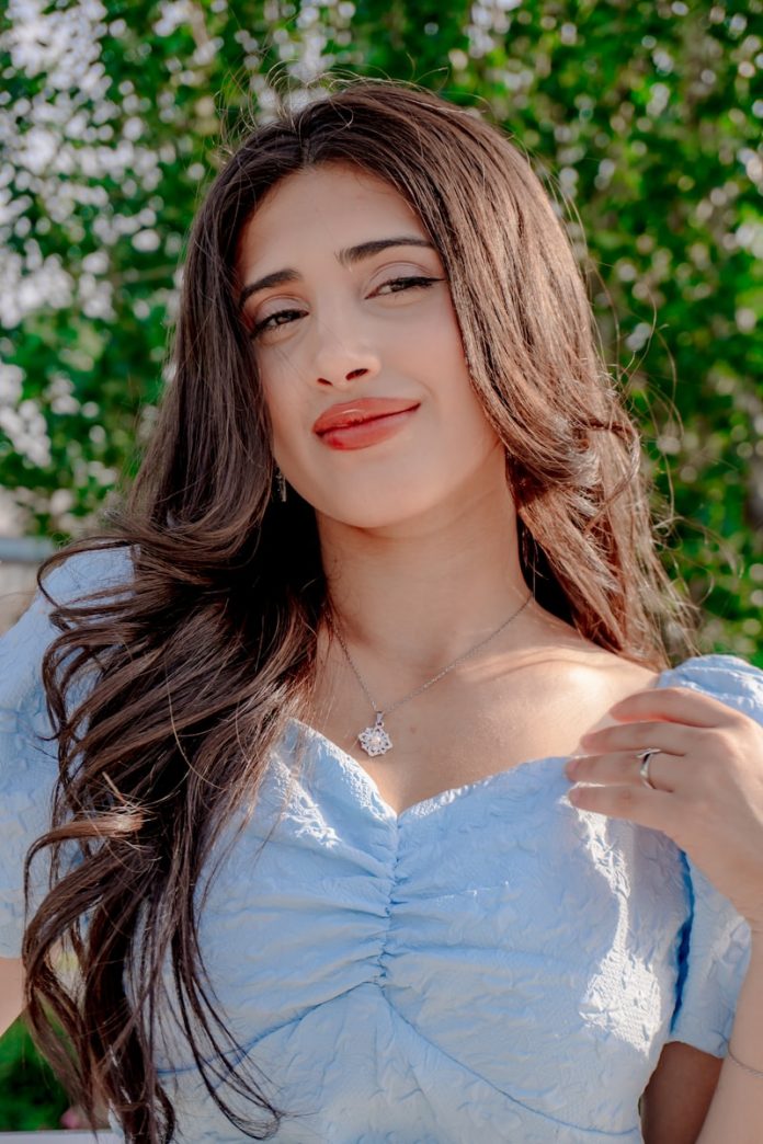 Young woman with long dark hair wearing blue