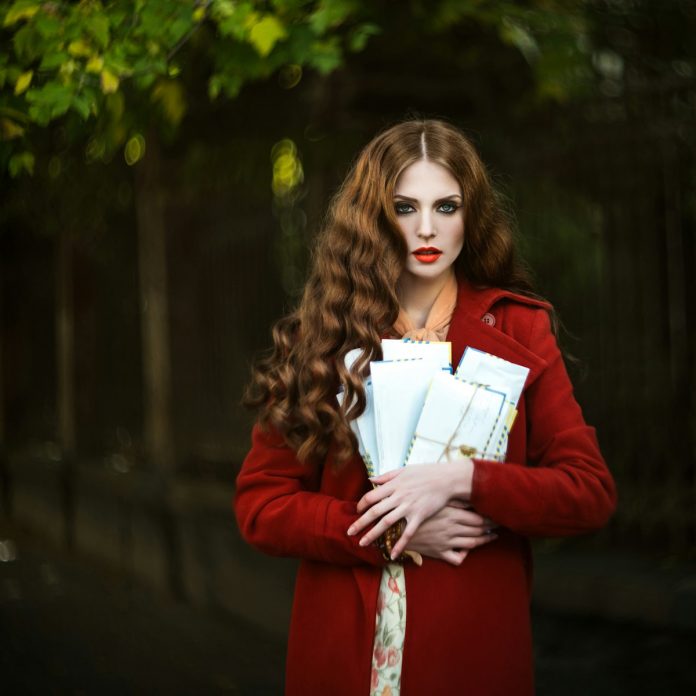 Woman with long red hair holding letters