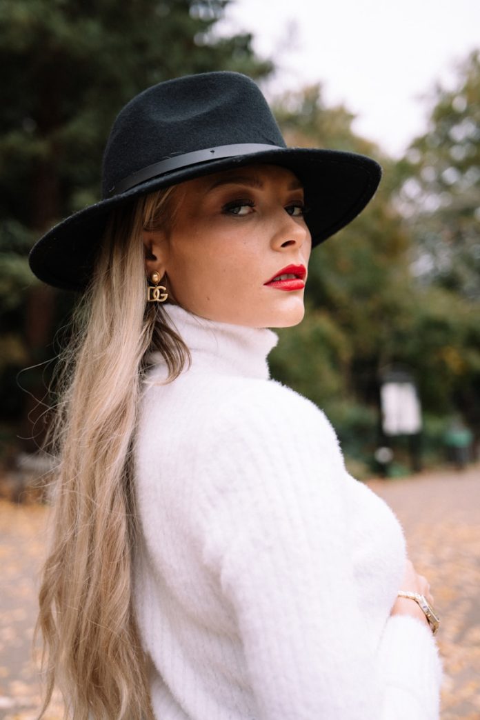 Woman wearing a black hat and white turtleneck